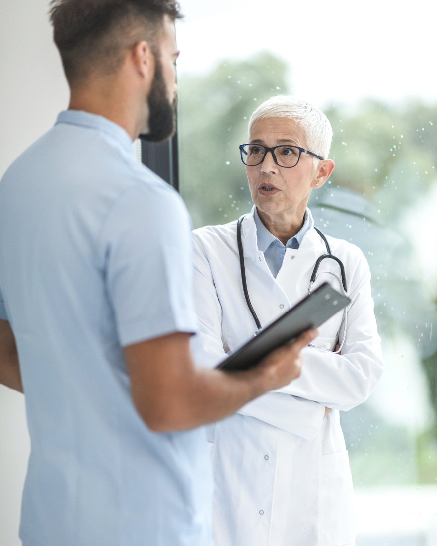 A physician reviewing a chart with a colleague in a clinic